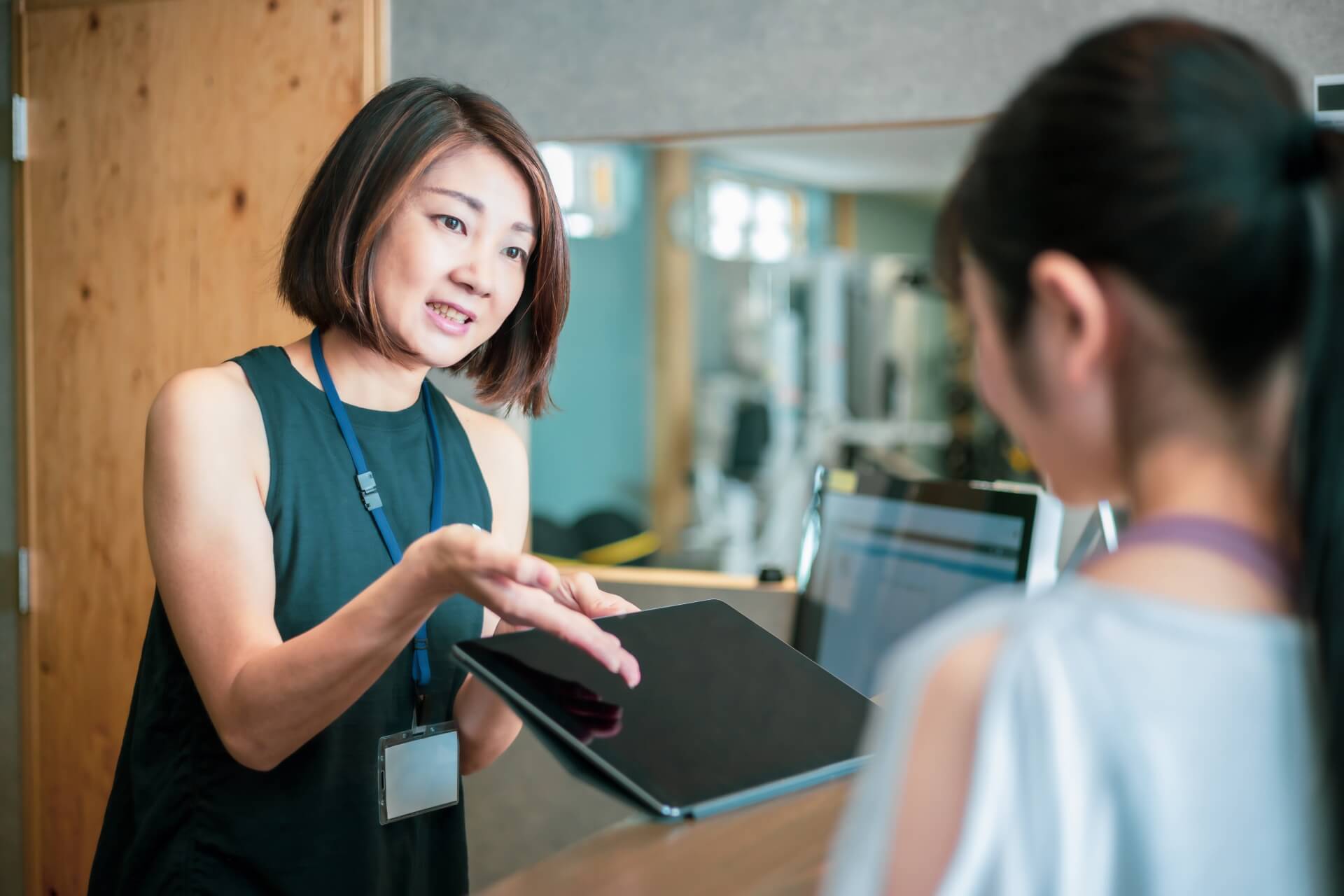 タブレットを使って案内する女性